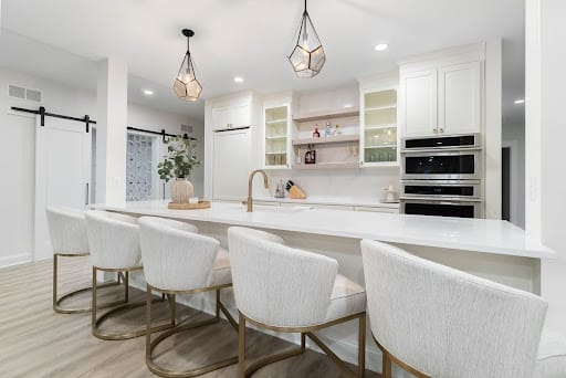 Beautiful kitchen with chairs in the foreground of the picture.