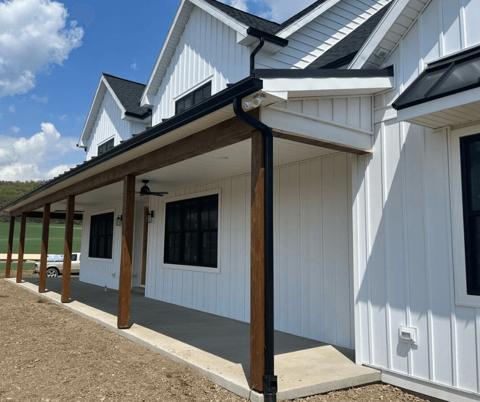 An addition that BiiLT constructed. It's the front of a white building with wooden pillars to support the covered porch. The roofing is back and makes the white walls pop.