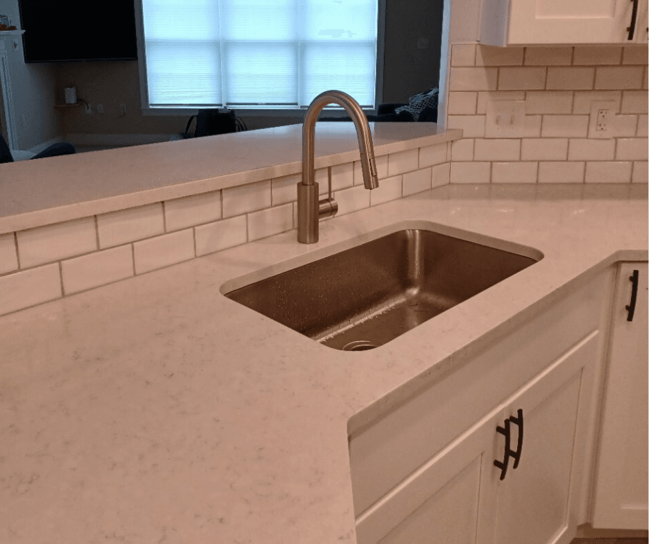 A primarily white counter top with a modern sink and faucet. Looks sleek and was a great example of BiiLT's work.