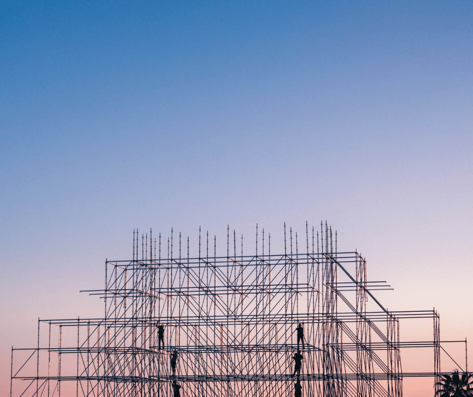 A sunset with a scaffold. It's zoomed out, with two people visible in the structure.