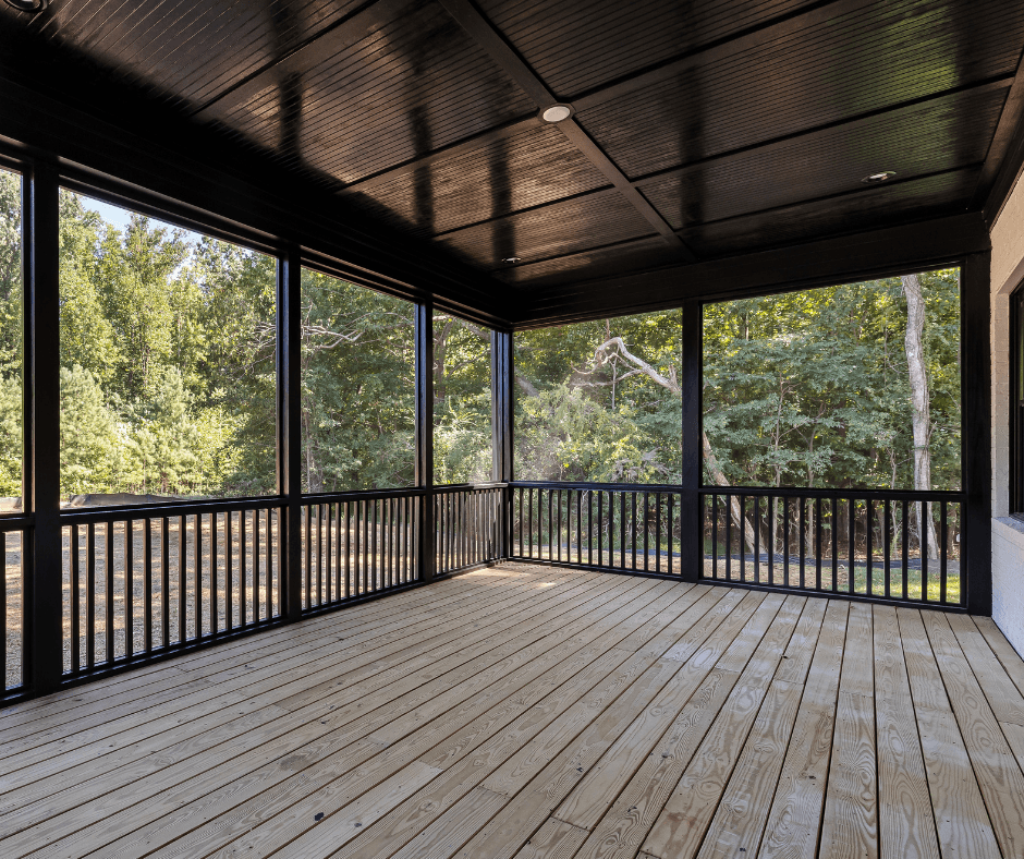 A Canva picture of a wraparound porch with a beautiful hardwood deck. There are black railings and supports.